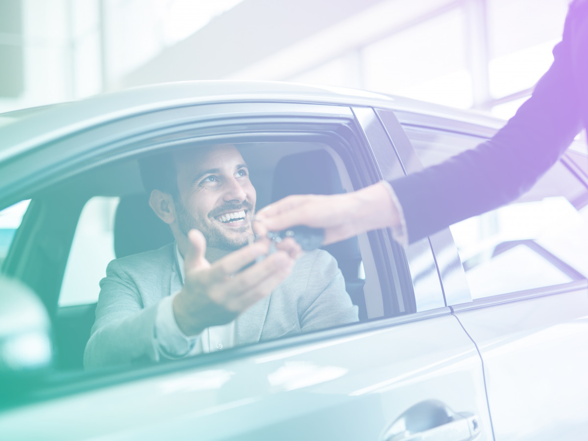 Man in a car receiving keys from someone else